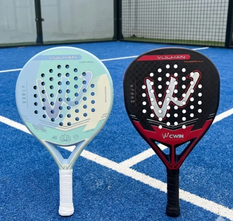 A side-by-side view of a light blue Vulkan Control racket and a red and black Vulhan Power racket on a blue court.